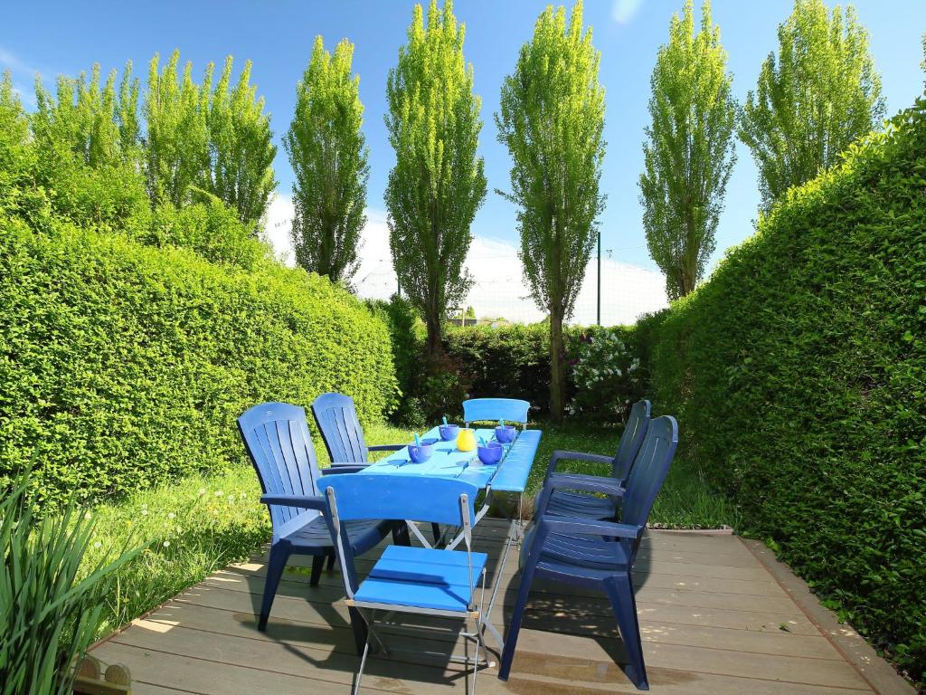 a blue table and chairs on a patio at Apartment Le Garden by Interhome in Cabourg