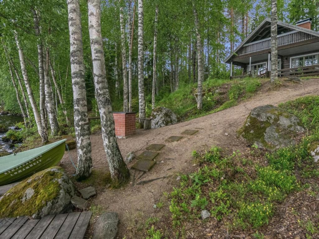 a cabin in the woods with a hammock in front at Holiday Home Laitamökki by Interhome in Tasapää