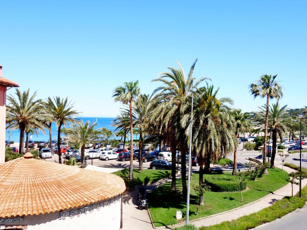 Elle offre une vue sur une rue bordée de palmiers et l'océan. dans l'établissement Apartment Les allées du Cap-2 by Interhome, à Antibes