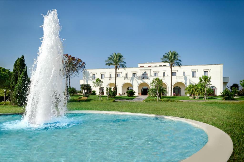 a fountain in front of a large building at Tenuta La Baronessa Resort in Tuglie