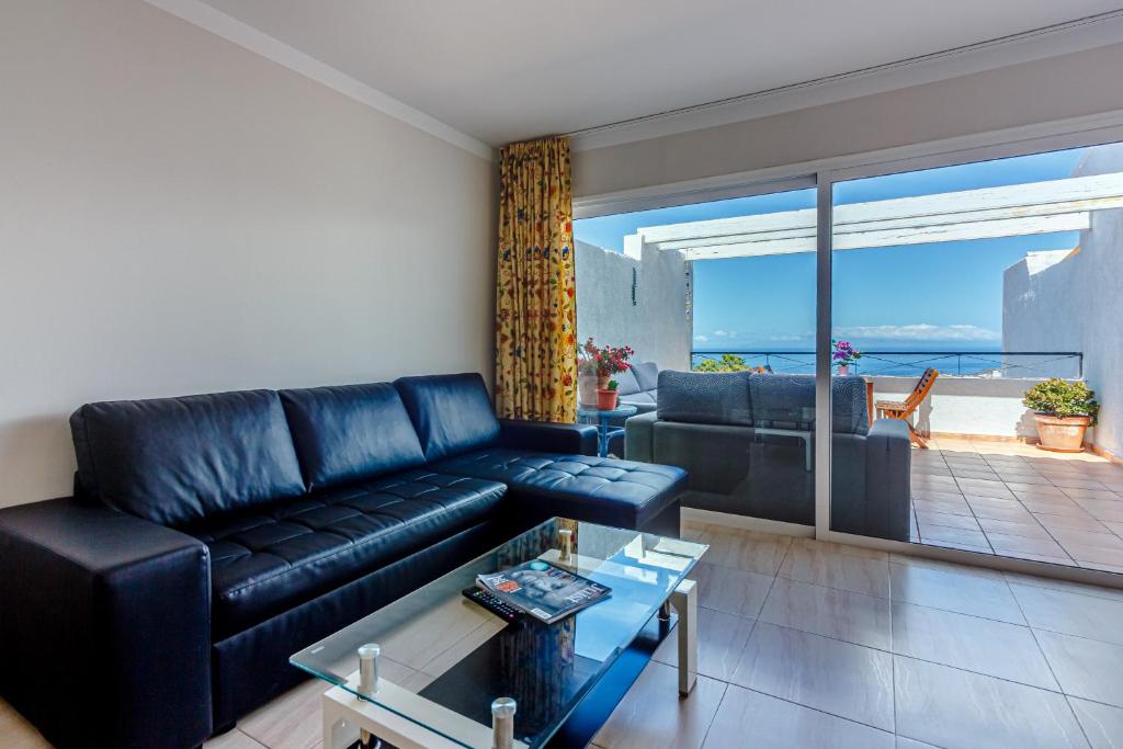 アデへにあるVillas canarias con vista al marのリビングルーム(黒い革張りのソファ付)が備わり、海の景色を望めます。
