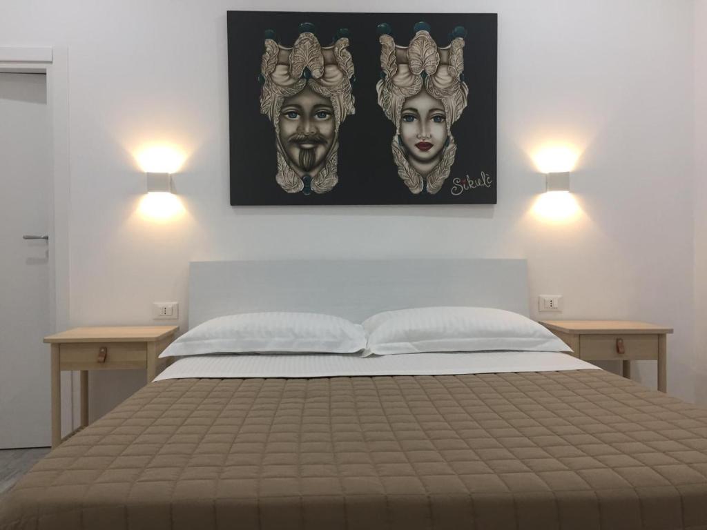 um quarto com uma cama com duas luzes na parede em Sikulè em Santa Teresa di Riva
