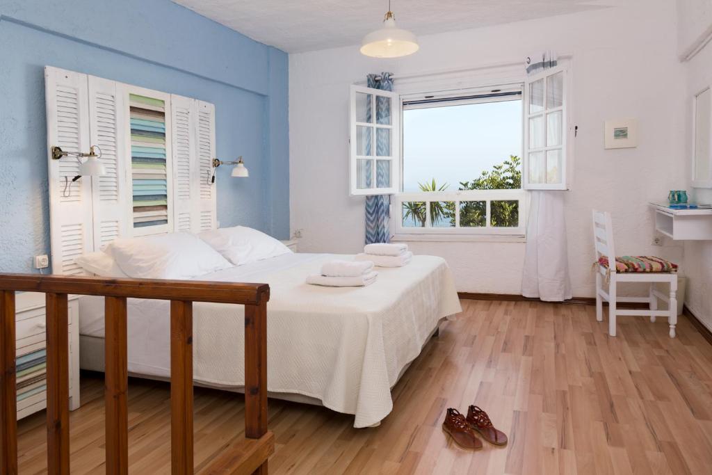 ein Schlafzimmer mit einem weißen Bett und einem Fenster in der Unterkunft Ferma Hill Apartments in Ferma