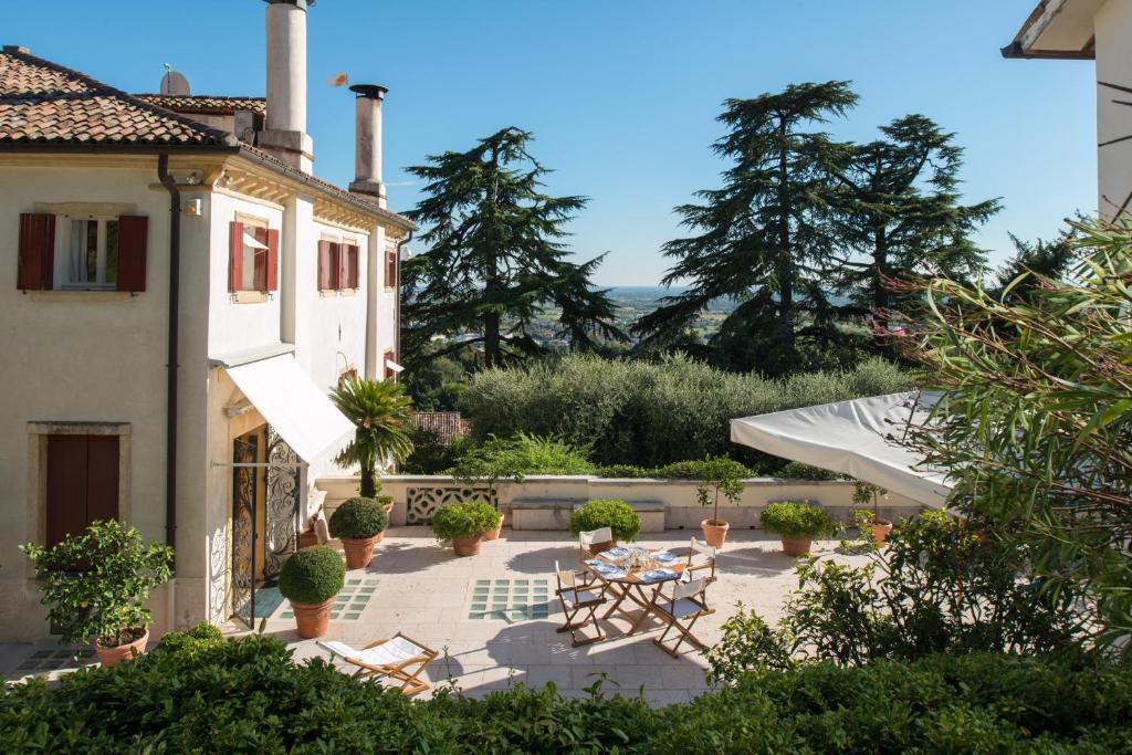 a house with a patio with a table and chairs at Villa il Galero in Asolo