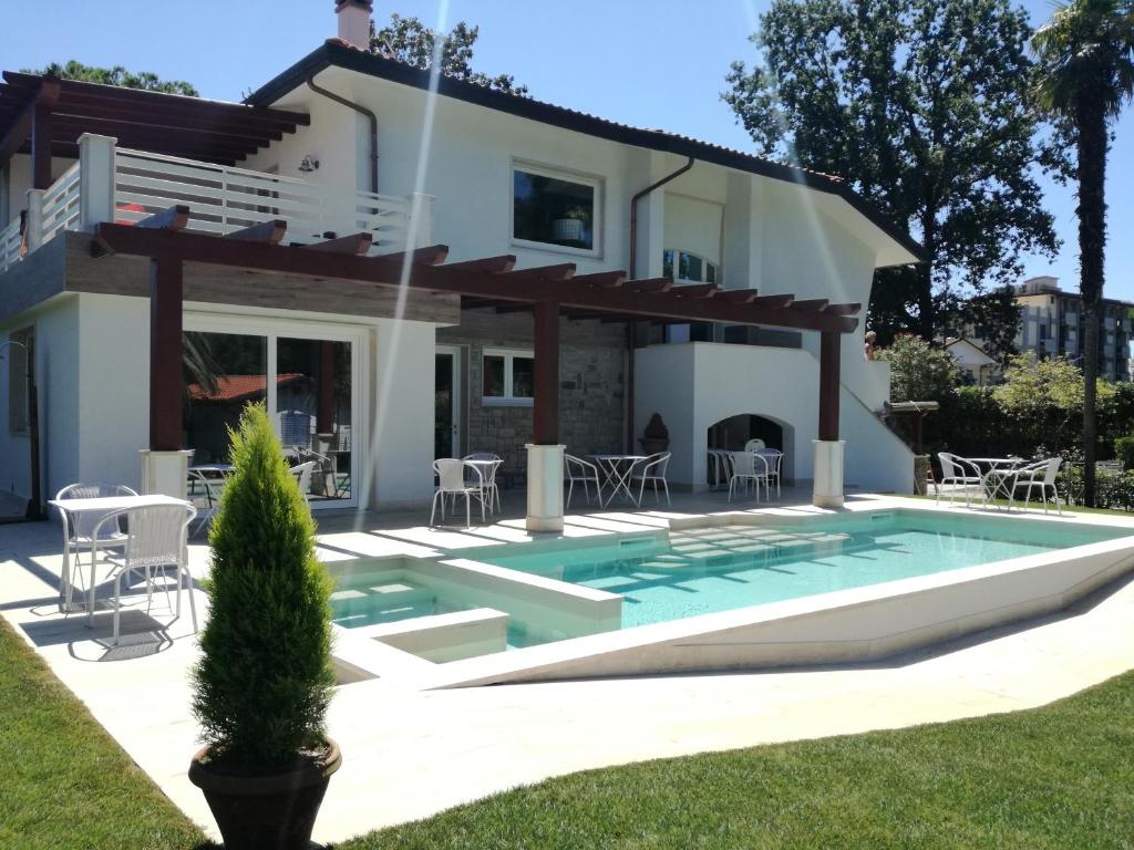 a villa with a swimming pool in front of a house at Il Gioiello B&B in Marina di Pietrasanta