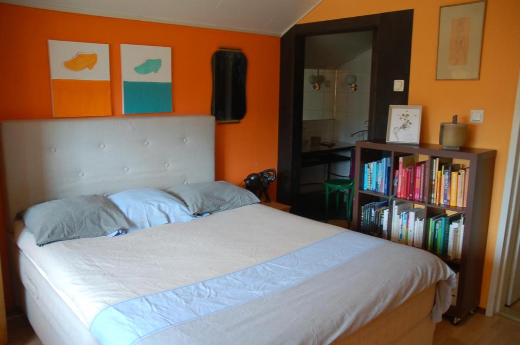 - une chambre avec un lit et une étagère avec des livres dans l'établissement Garden Villa Lahti, à Lahti