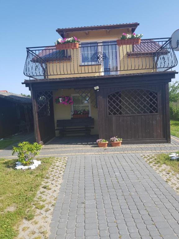 uma casa com varanda e um banco em frente em Monika em Leba