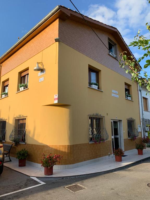 un edificio amarillo con ventanas con barrotes en una calle en Vivienda Vacacional El Majo, en Siero