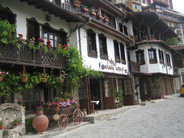 ein Gebäude mit Blumentöpfen und Balkonen auf einer Straße in der Unterkunft Gurko Hotel in Weliko Tarnowo