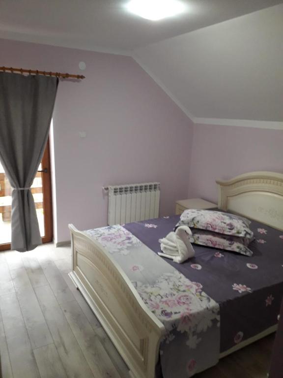 a bedroom with a large bed in a room with a window at La pastravaria Cerna in Râu de Mori