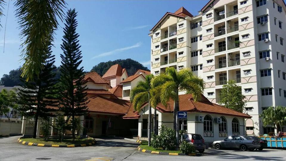 a large white building with palm trees in front of it at Harnizam Muslim Homestay in Tambun