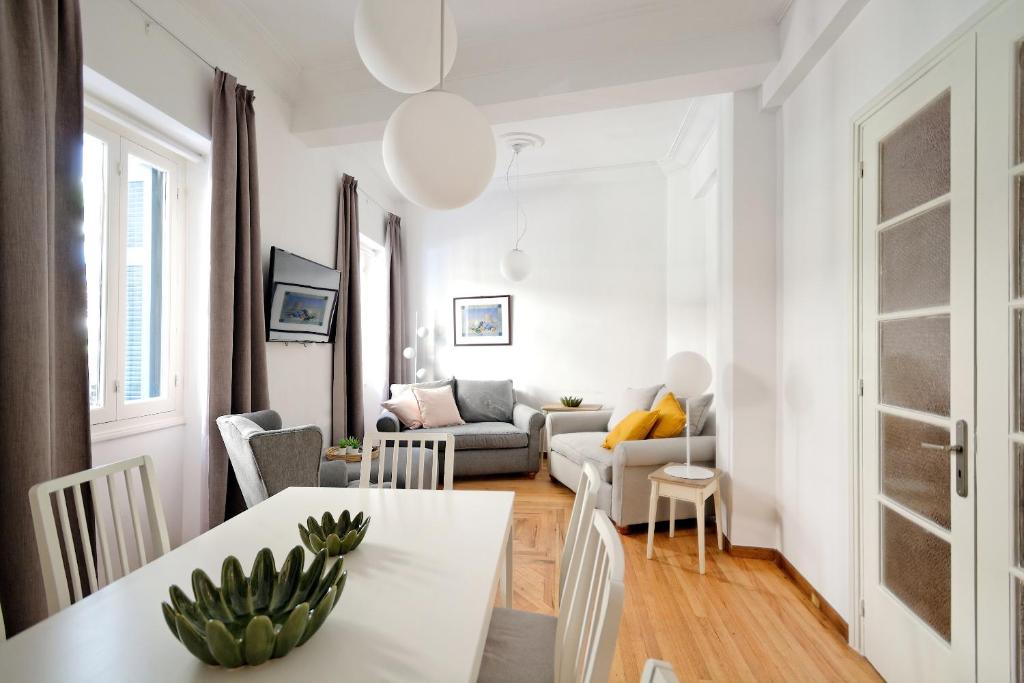 - un salon blanc avec une table et un canapé dans l'établissement Art in Athens Suite, à Athènes
