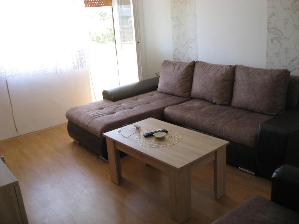 a living room with a brown couch and a coffee table at Apartman Daca Apatin in Apatin