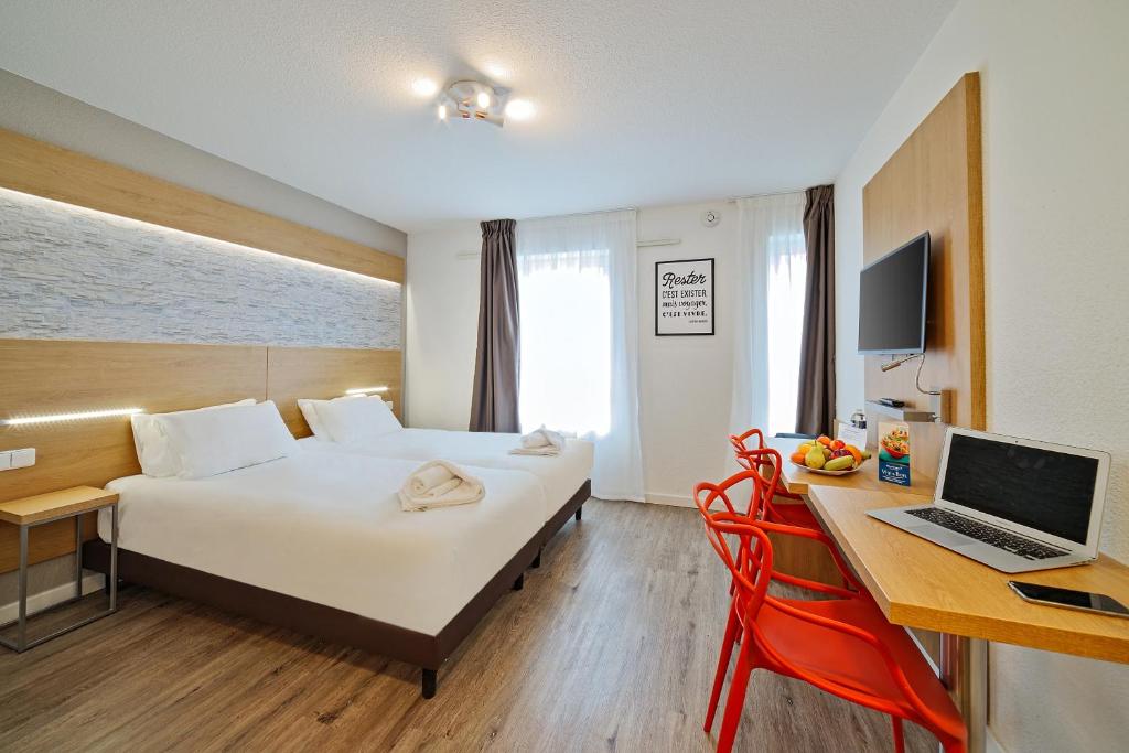 een hotelkamer met een bed en een bureau met een laptop bij Residhotel Lyon Part Dieu in Lyon