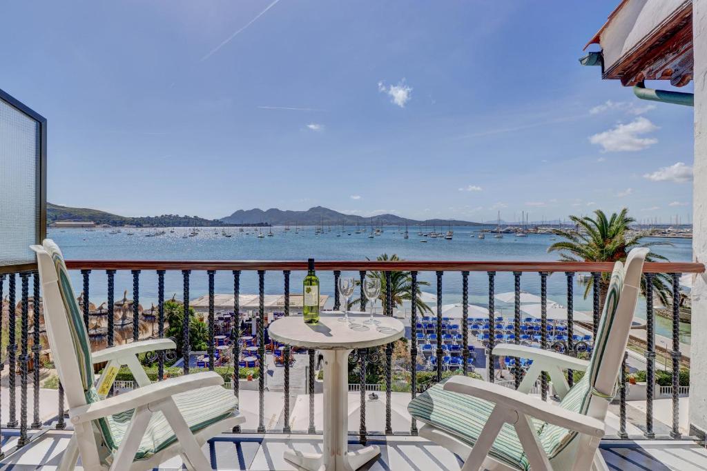 balcone con tavolo, sedie e spiaggia di Hotel Sis Pins a Port de Pollença