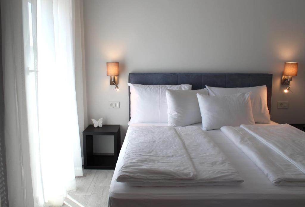 a bed with white sheets and pillows in a bedroom at Pansion Leggero in Krk