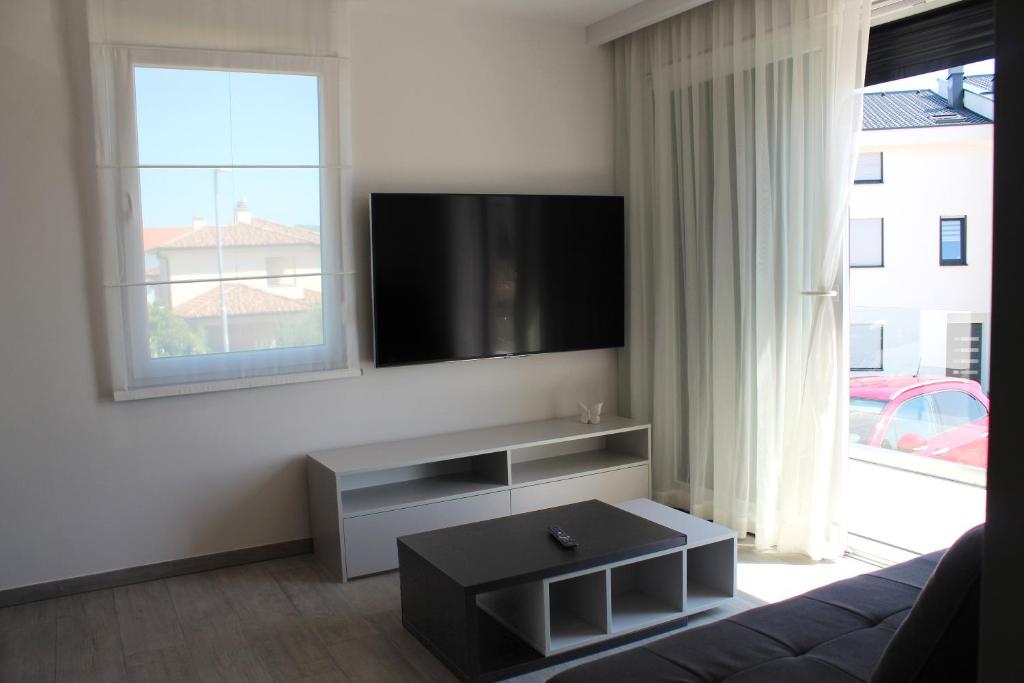a living room with a couch and a flat screen tv at Pansion Leggero in Krk