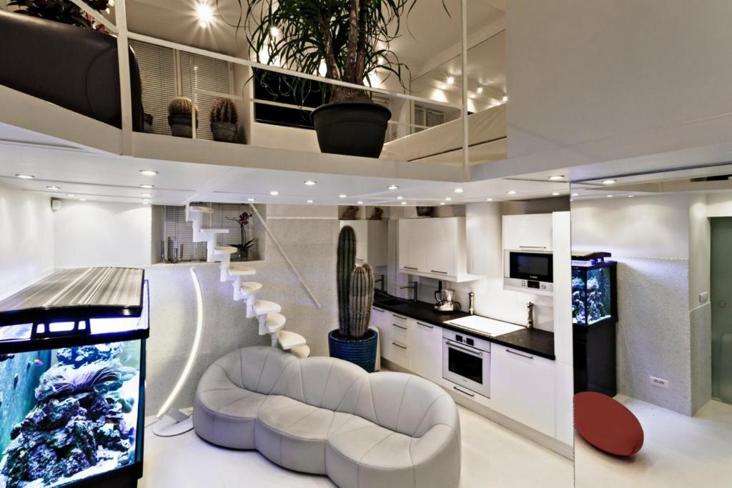 a living room with white furniture and a kitchen at Stylish,luxury duplex Paris city center in Paris