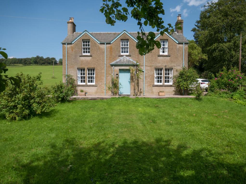 an old brick house with a large yard at Bamff Ecotourism in Alyth