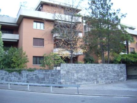eine Bank, die vor einem Backsteingebäude sitzt in der Unterkunft Residenz degli Angioli in Ascona