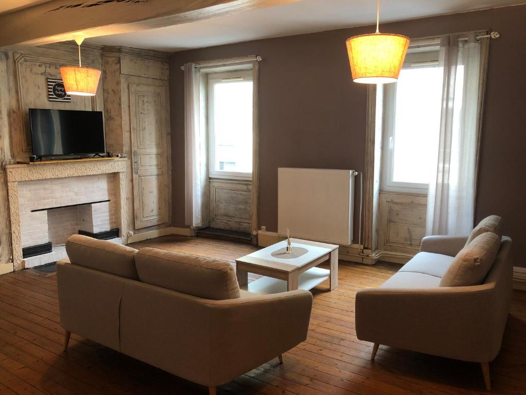 sala de estar con 2 sofás y chimenea en Spacieux appartement 2/6 pers 110m² proche CNPE, en Lagnieu