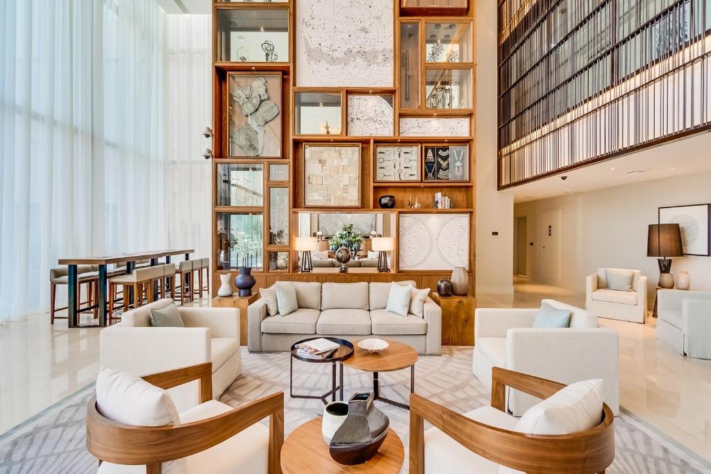 a living room with white furniture and a large wall of windows at Vida Downtown Residences in Dubai