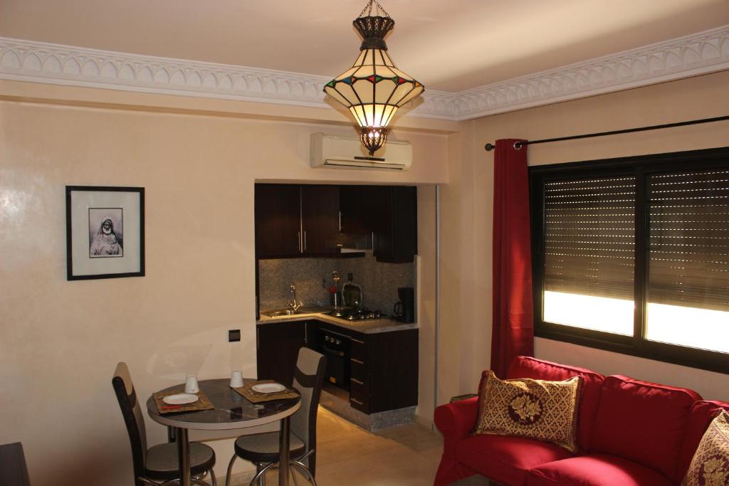 een woonkamer met een tafel en een rode bank bij Studio Salmiya Dune in Marrakesh