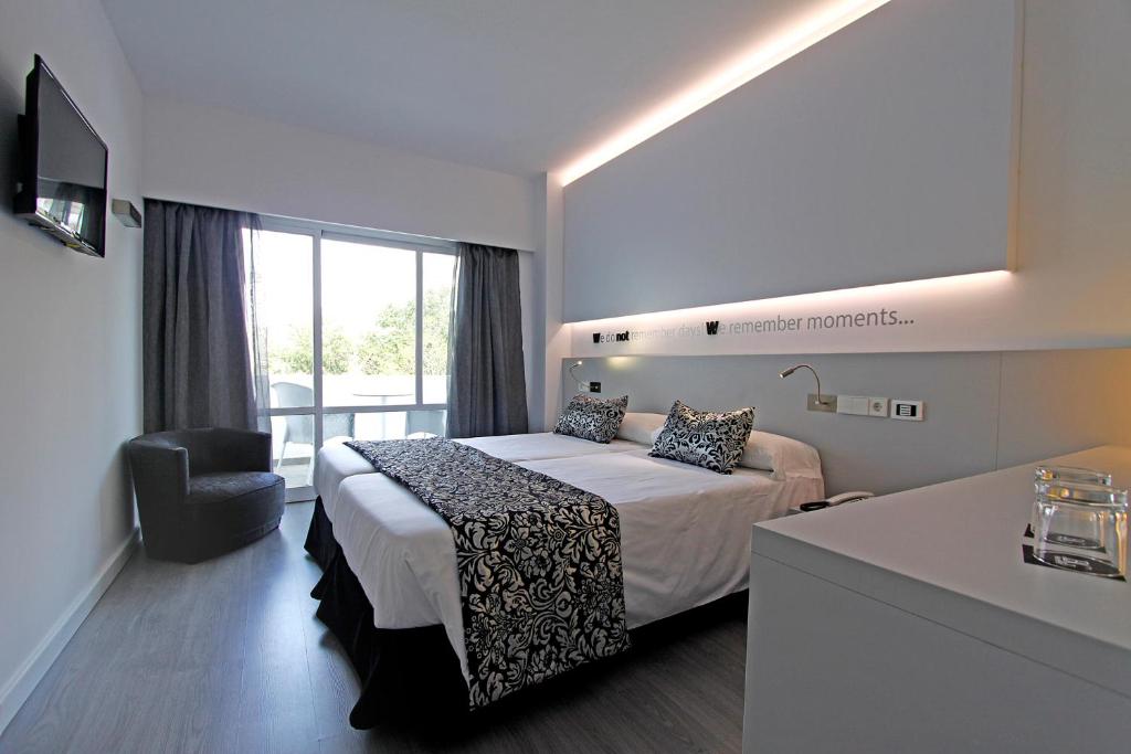 um quarto de hotel com uma cama e uma cadeira em BG Pamplona em Playa de Palma