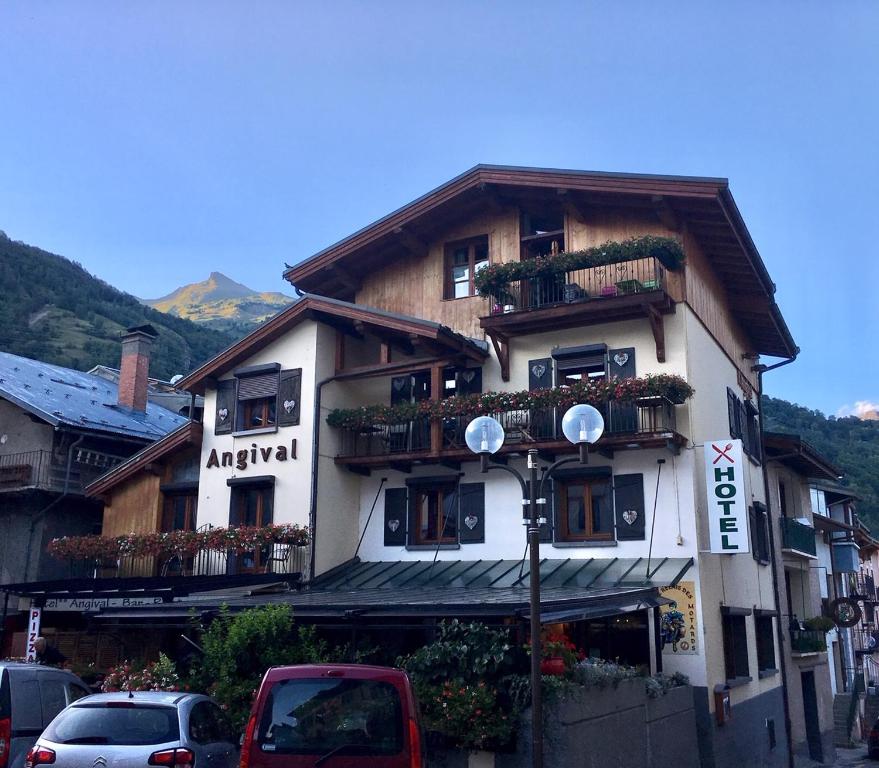 un grand bâtiment avec des plantes sur ses balcons dans l'établissement Hôtel Restaurant Angival - Chambres et Appartement, à Bourg-Saint-Maurice