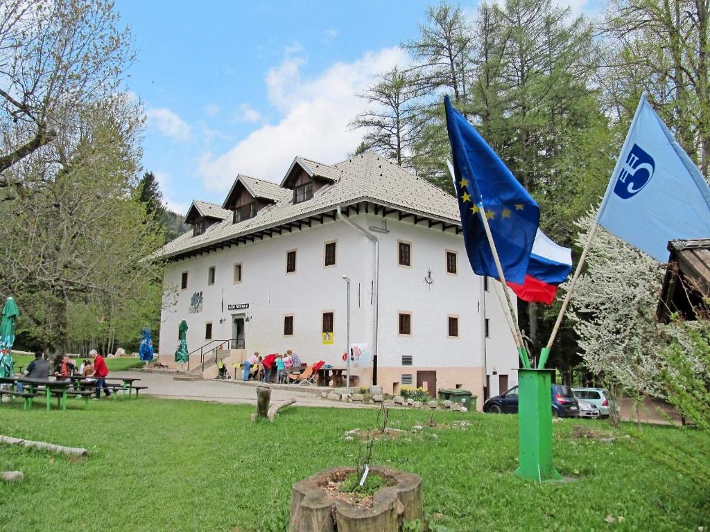 dos banderas delante de un edificio blanco en Dom Pristava, en Jesenice