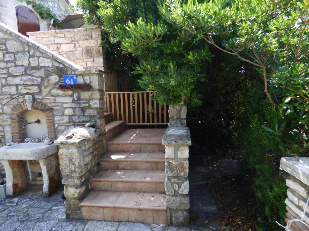 a wooden staircase leading to a house with a tree at HEDRA in Zambratija