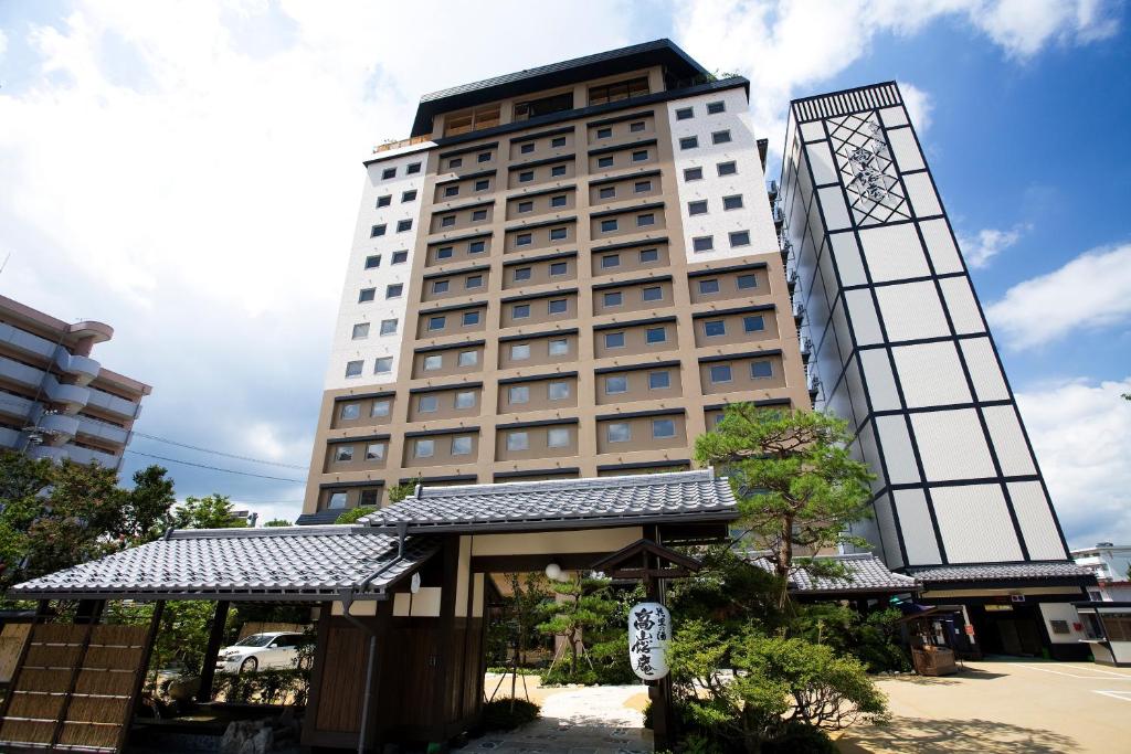 a tall white building with a sign in front of it at Takayama Ouan in Takayama