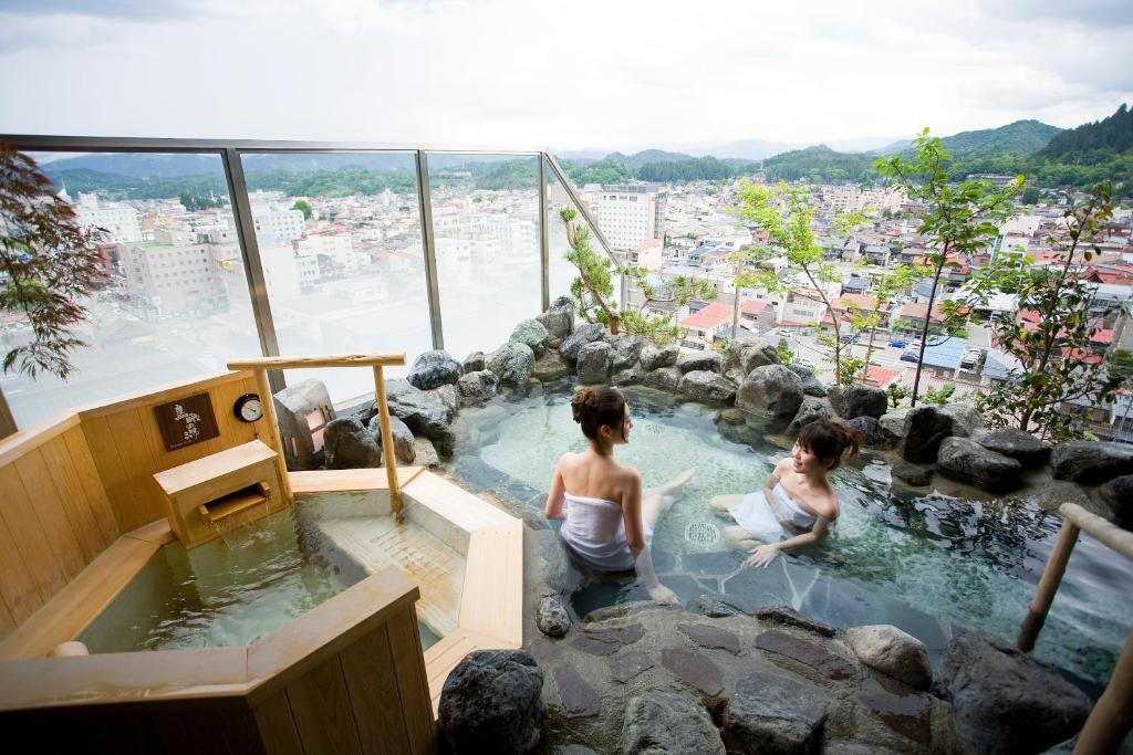 two women in a jacuzzi tub in a building at Takayama Ouan in Takayama