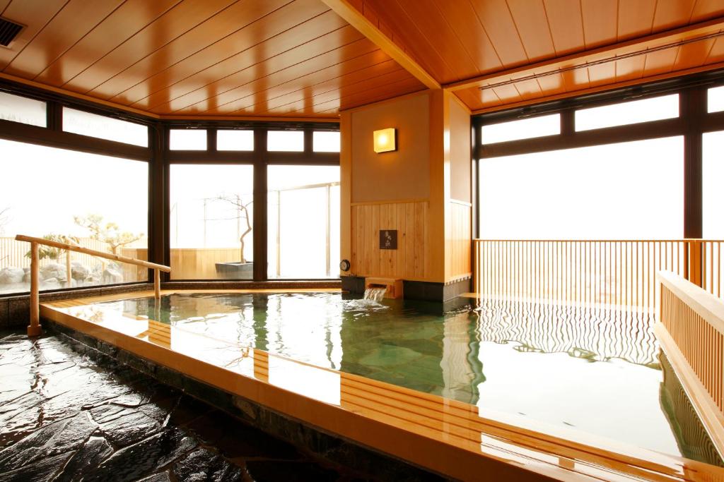 a pool of water in a room with windows at Takayama Ouan in Takayama