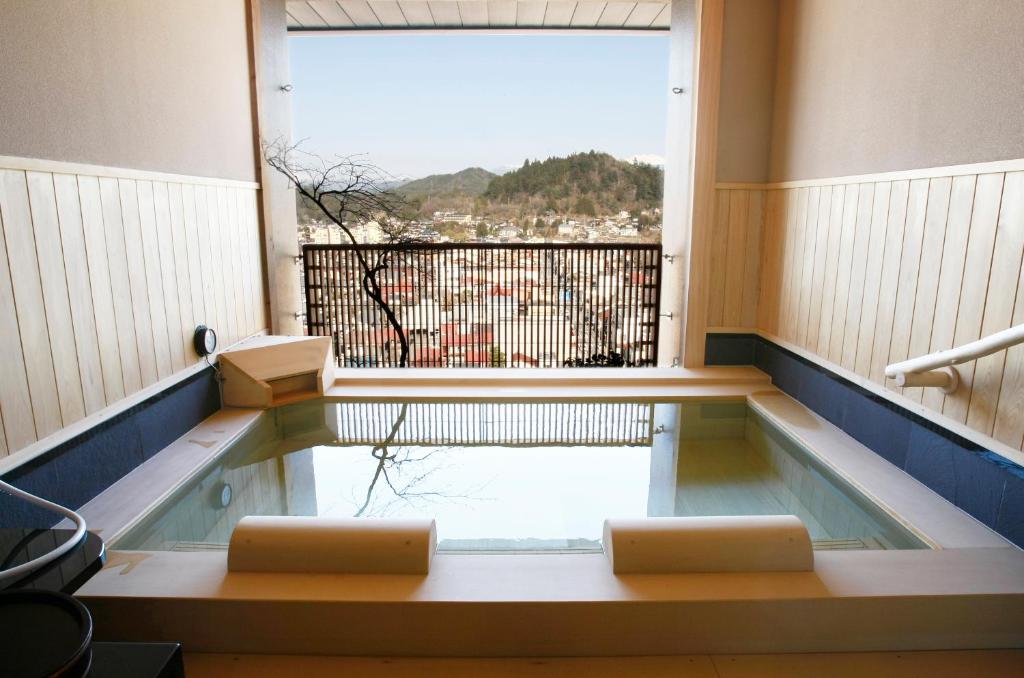 a room with a swimming pool with a large window at Takayama Ouan in Takayama
