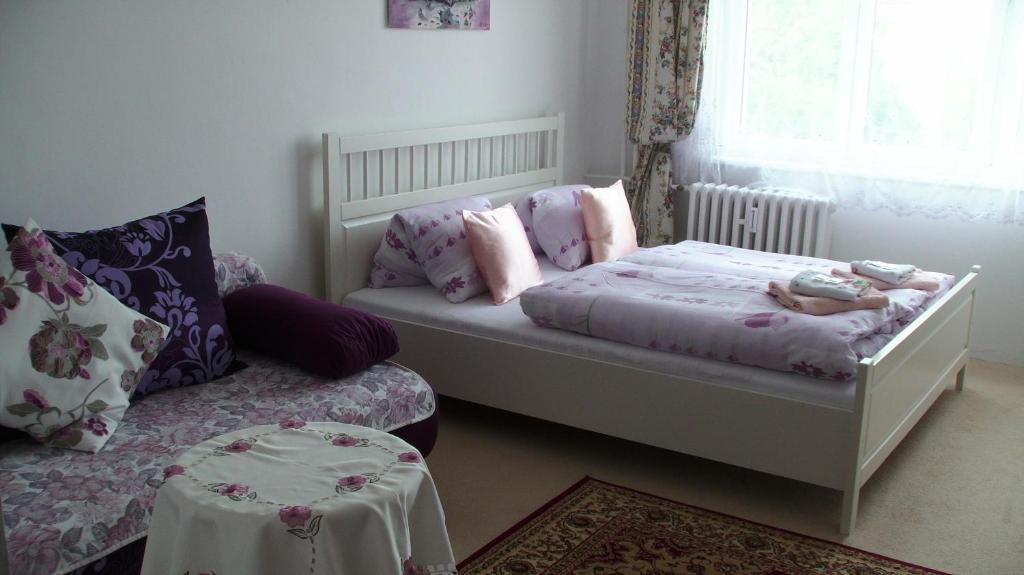 a small bedroom with a bed and a couch at Apartments Meixner in Mariánské Lázně