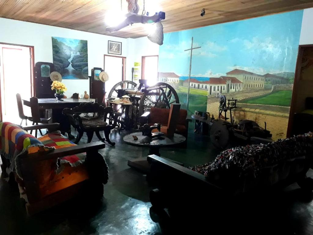 una sala de estar llena de muebles y un mural en Pousada Mirante das Pedras, en São Thomé das Letras