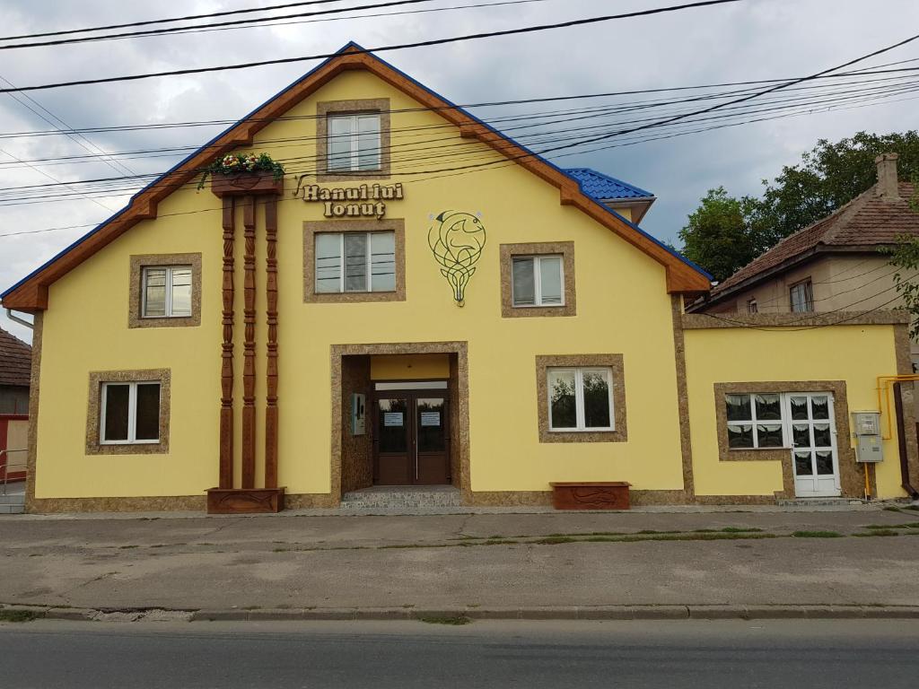 a yellow building with a sign on it at Hanul Lui Ionut in Satu Mare