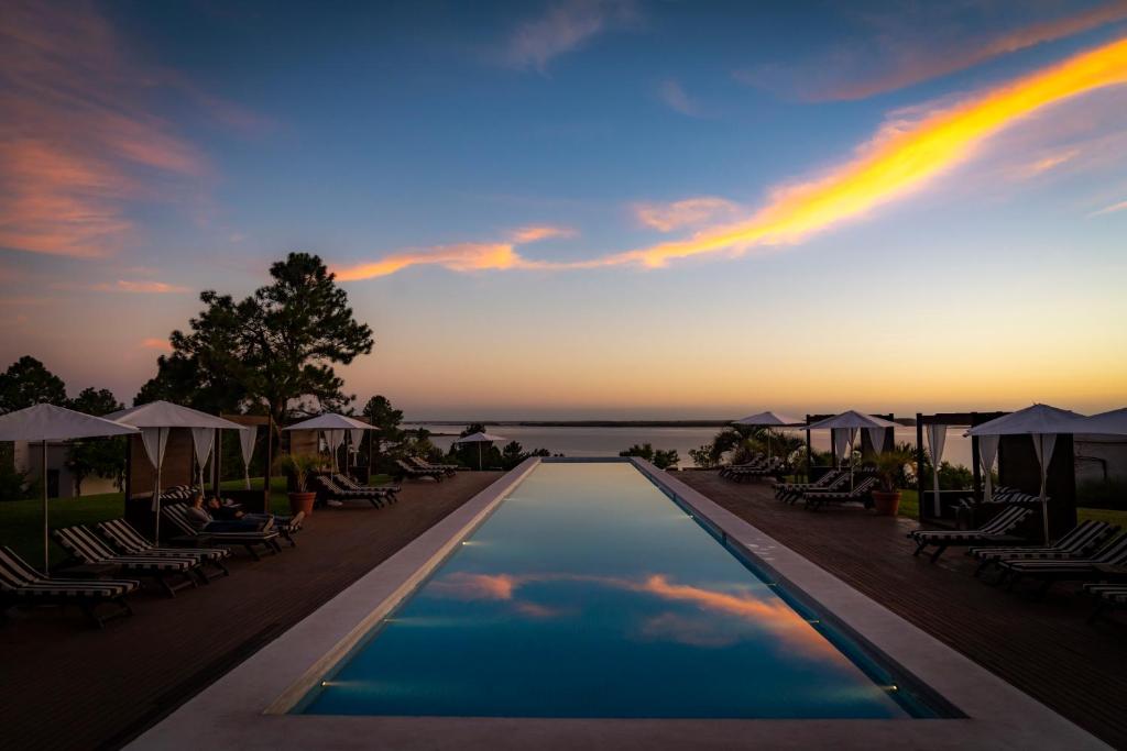 a pool at a resort with a rainbow in the sky at Casa Chic Carmelo - Club de Campo in Carmelo