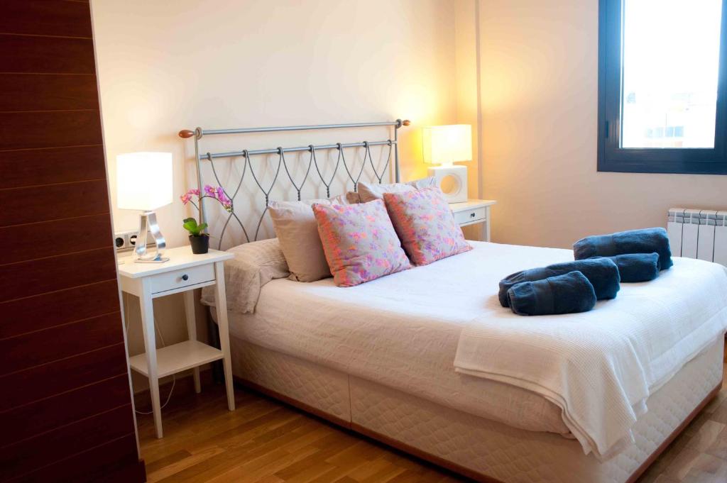 Un dormitorio con una cama con almohadas azules. en Alcam Barbera Terrazas, en Barberà del Vallès