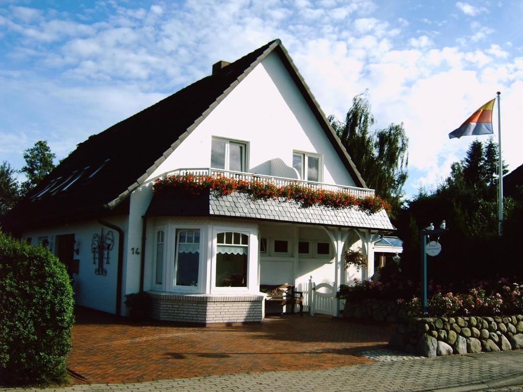 ein weißes Haus mit einer Flagge auf der Seite in der Unterkunft Gästehaus Ziemann in Friedrichstadt