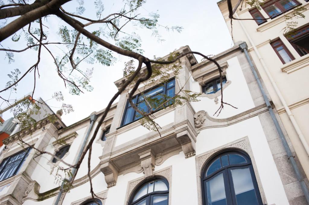 ポルトにあるFMO APARTMENTS BOAVISTAの青窓と木のある建物