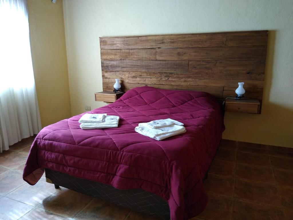 um quarto com uma cama roxa com duas toalhas em Nonno Aldo Casa de campo em Maipú