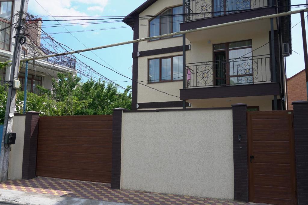 uma casa com um portão de madeira e uma cerca em ARKADIYA HOUSE em Odessa