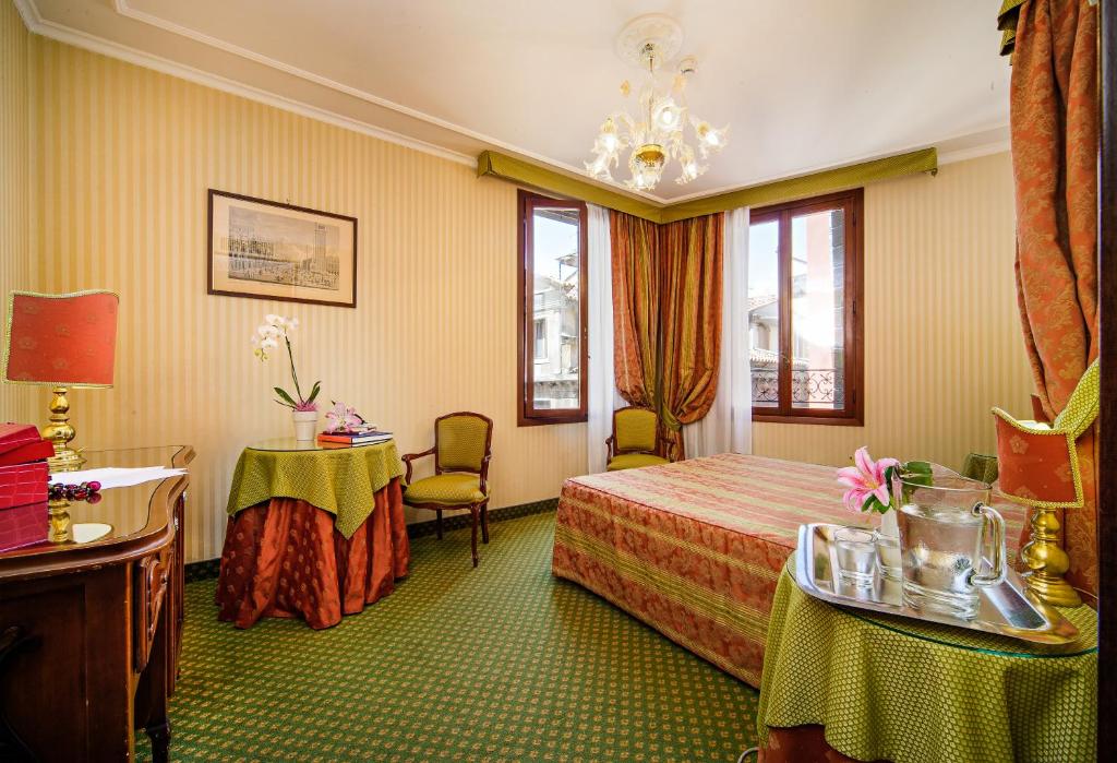 a hotel room with a bed and a table and chairs at Hotel Kette in Venice