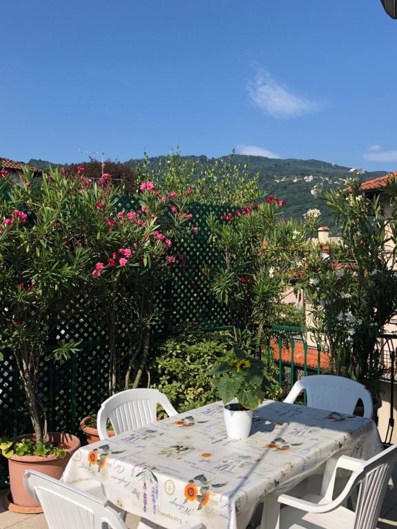 uma mesa e cadeiras num pátio com flores em La Terrazza degli Oleandri em Stresa
