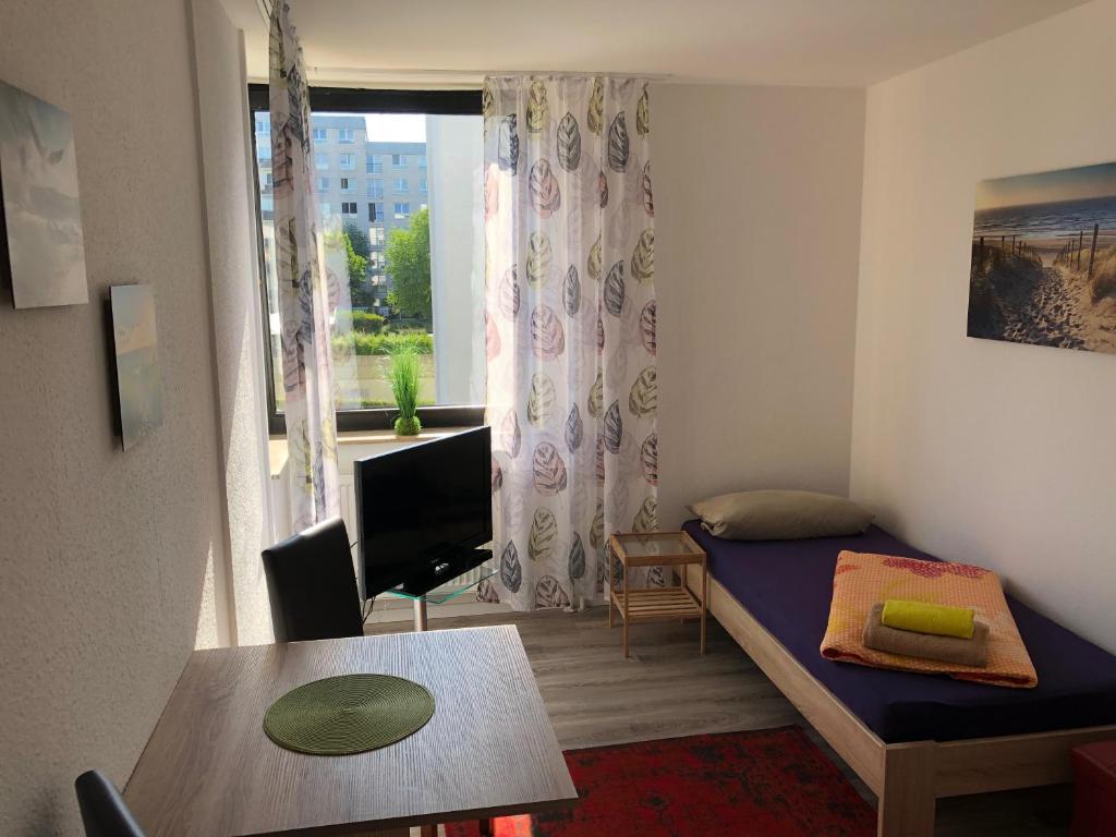 Appartement Mainz Universität في ماينز: غرفة نوم بسرير وطاولة ونافذة