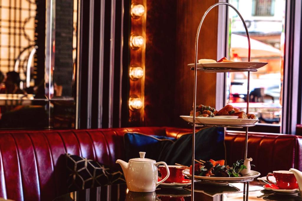 A tiered afternoon-tea-style spread served in a red leather restaurant booth.
