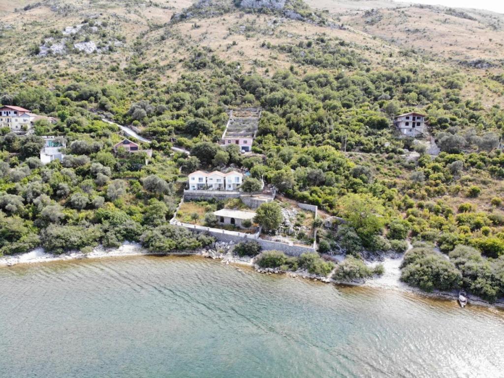 an aerial view of a house on a hill next to the water at Vani i Bardhë in Zogaji