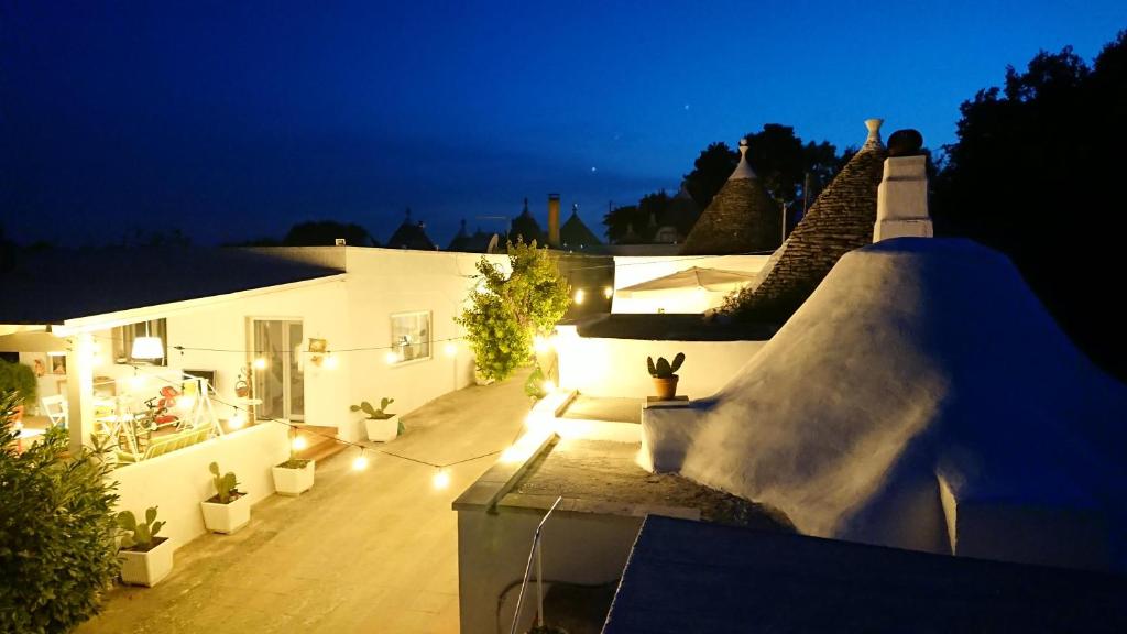 a house with a lit up backyard at night at Trulli La Cariola in Locorotondo